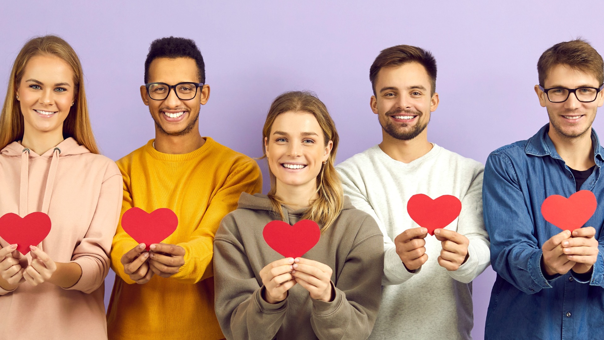 Cambermast training graduates smiling and holding red hearts.